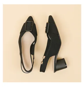 Close-up of black knit pointed-toe slingbacks showing buckle detail and sturdy block heel