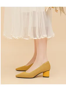Close-up view of stylish yellow pointed toe pumps with a block heel and ribbed knit texture