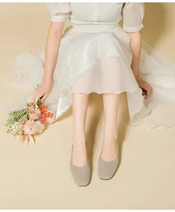 Elegant beige knit square-toe flat shoes for women shown on feet with a floral prop