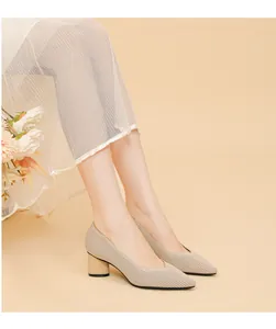 Close-up of beige pointed toe pumps with chunky heel and ribbed texture detail.
