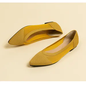 Detailed view of yellow knit pointed-toe ballet flats with breathable mesh texture
