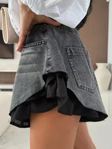 Dettaglio di pantaloncini in denim lavato a vita alta con orlo a balze a strati e bordi sfilacciati