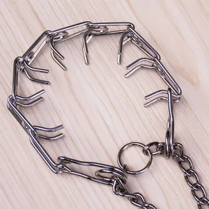 Detailaufnahme eines silbernen Metall-Stachelhalsbandes für Hunde auf Holzgrund