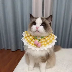 Dettaglio di un gatto che indossa un collare per animali a scacchi gialli con ciliegie