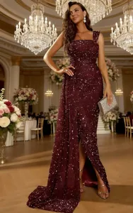 Élégante robe de soirée à paillettes bordeaux avec fente latérale dans une salle de bal