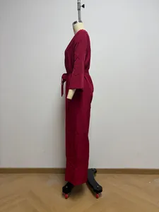 Side view of a French style wine red long-sleeved wide-leg jumpsuit with waist belt