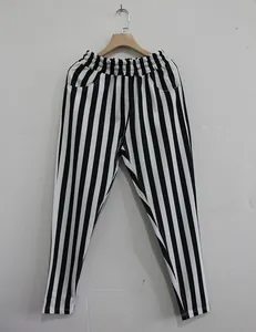 Detailed view of men's black and white vertical striped sports trousers hanging on a hanger.
