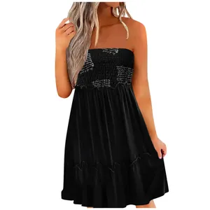 Detailed view of black smocked tube top dress with elegant white script printing.