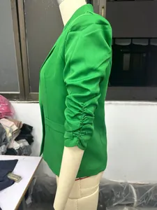 Vue latérale détaillée d'un blazer vert avec d'élégantes manches trois-quarts froncées