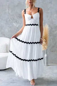 Détail de la robe longue blanche à volants avec bordure ondulée ric-rac noire et bretelles