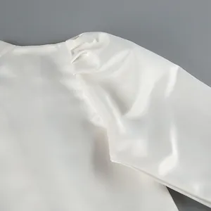 Close-up detail of vintage puff sleeves and matte satin fabric texture on a white shirt.