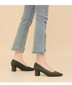 Close-up detail of dark green ribbed pointed toe chunky heel pumps worn on model feet