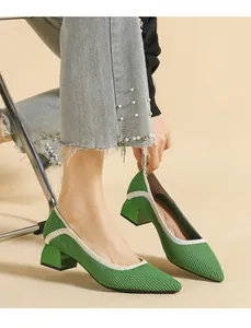 Close-up view of vibrant green knit chunky heel pumps with pointed toe on a model.