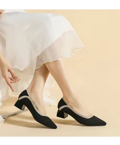 Detail of black knitted pointed-toe pumps with elegant block heel and beige wavy trim.