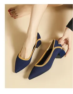 Close-up of navy knit pointed-toe pumps with yellow trim and stylish block heel