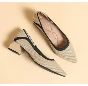 Close-up of beige knit pointed-toe block heel pumps with black trim.