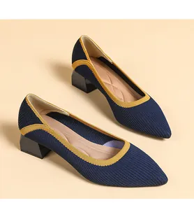 Close-up of blue knitted pointed-toe shoes with yellow trim and chunky block heels