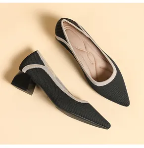 Detailed view of black knit pointed-toe pumps with elegant beige trim and block heels
