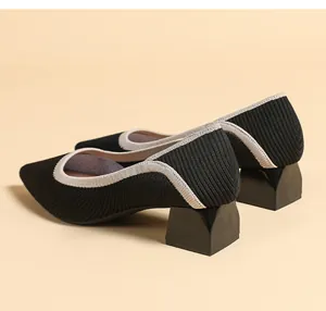 Detailed side view of stylish black knit pointed-toe pumps with geometric block heels