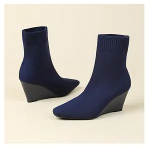Detailansicht von dunkelblauen Strick-Stiefeletten mit elegantem Keilabsatz-Design.