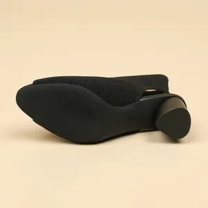 Close-up detail view showing the textured anti-slip sole and chunky heel of a black knitted bootie