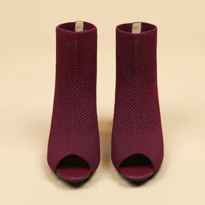 Close-up of burgundy knit peep-toe ankle boots featuring intricate hollow mesh texture