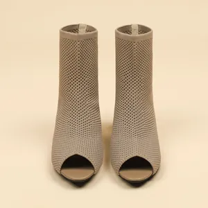 Close-up of peep-toe knit ankle boots featuring a delicate hollow-out woven texture.
