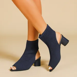 Detailed side view of navy blue peep-toe knit mule boots with a stable chunky mid heel