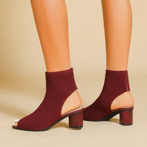 Detailed view of burgundy knit peep-toe ankle boots featuring stylish cutout heel design