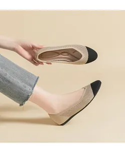 Vista dettagliata di scarpe piatte in maglia beige traspirante con punta tonda nera.