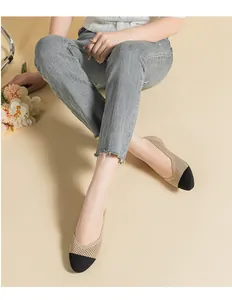 Scarpe piatte in maglia beige e nera traspiranti ed eleganti indossate da una modella