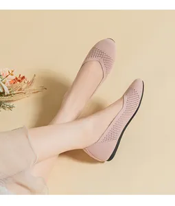 Dettaglio ravvicinato delle ballerine in maglia rosa traspirante su sfondo beige