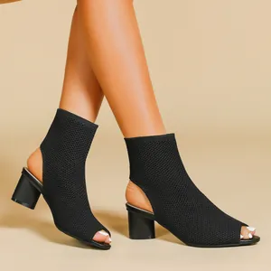 Detailed close-up view of black knitted peep-toe ankle boots with chunky heels