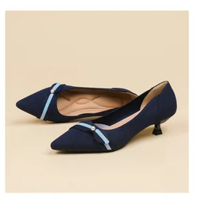 Detail view of navy blue pointed-toe kitten heels featuring fly-knit texture and pearl.