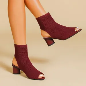 Detail view of burgundy knitted peep-toe ankle boots with a chunky block heel.