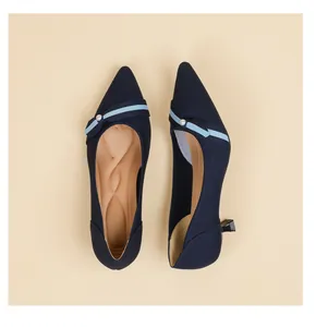 Detailed view of navy blue knit pointed-toe kitten heels with pearl and stripe detail