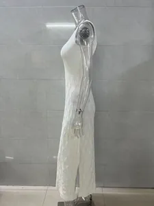 Side view of white knit maxi dress featuring intricate open-work texture and elegant profile.