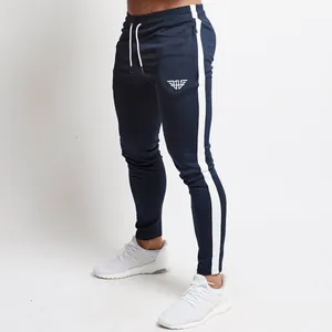 Detailed side view of navy blue slim fit sports joggers with white stripes.