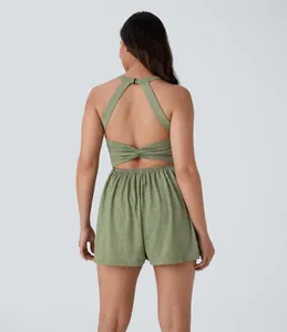 Back view of a sexy green sleeveless halter romper with twist detail and elastic waist.