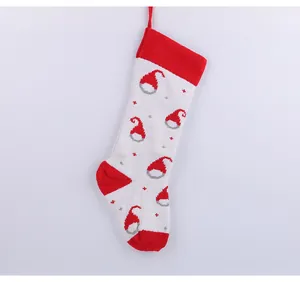 Close-up detail of a white knitted Christmas stocking with a red Santa hat pattern