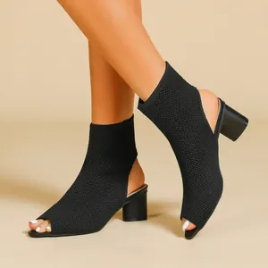 Detail view of black knit peep-toe booties featuring a sturdy block heel design