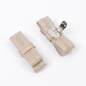 Detailed view of beige knit bow shoe clips with durable silver metal fasteners.