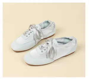 Side view of elegant light blue ballet sneakers featuring soft suede and satin ribbon