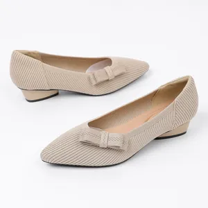 Detail shot of detachable beige knitted bow accessories on elegant low-heel shoes