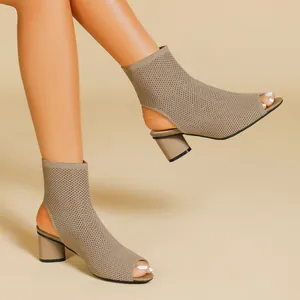 Close-up detail of khaki knit open-toe ankle boots with chunky heels and cutout design