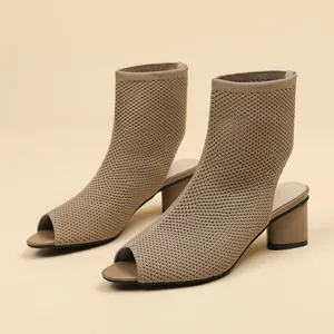 Macro view of women's peep toe knit ankle boots featuring breathable hollow design and block heels