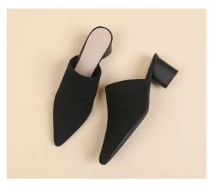 Close-up detail of black pointed-toe chunky heel mules with breathable knitted fabric