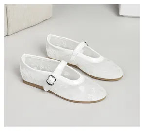 Detailed close-up of white breathable mesh Mary Jane flats with floral embroidery.