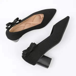 Close-up of black knitted pointed-toe pumps featuring an elegant bow detail on the heel.