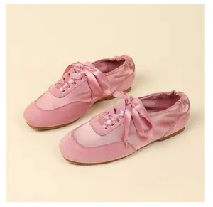 Elegant pink satin ballet flats featuring ribbon laces and soft suede toe details